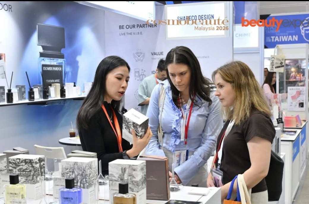 Buyers examine a fragrance range at an exhibitor stand at Cosmobeaute Malaysia 2026, with Taiwan pavilion signage behind