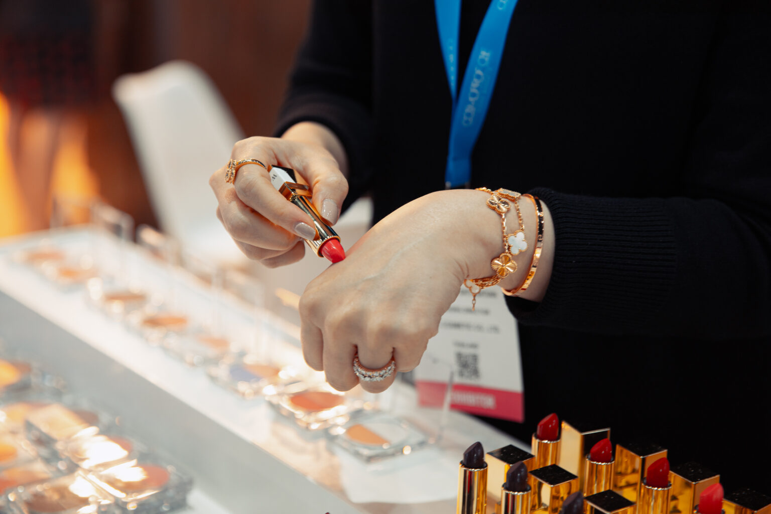 A buyer swatches colour cosmetics at an exhibitor booth during the 2025 edition.